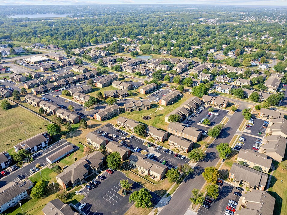 an aerial view of a neighborhood with cars parked in a parking lot