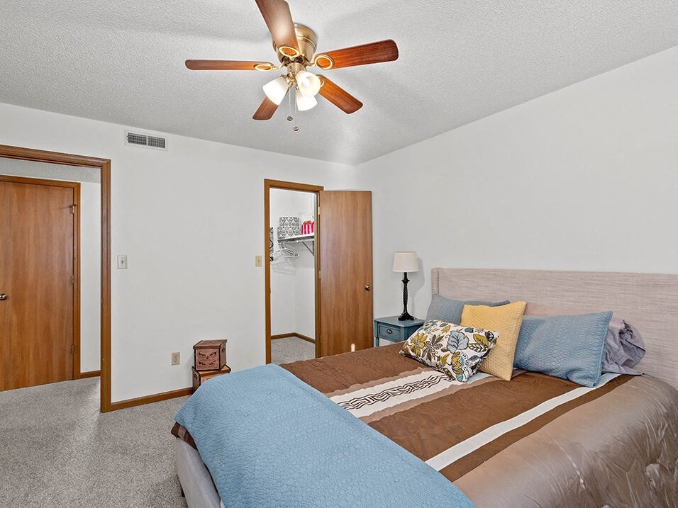 a bedroom with a large bed and a ceiling fan