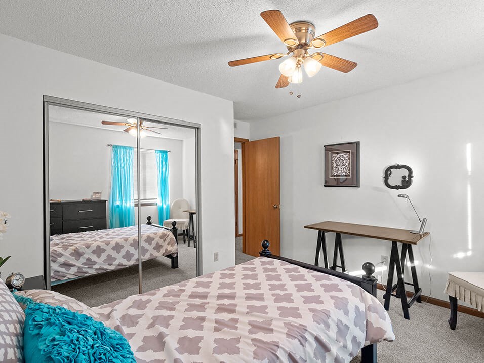 a bedroom with a bed and a ceiling fan