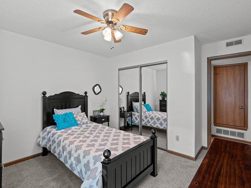 a bedroom with a bed and a ceiling fan