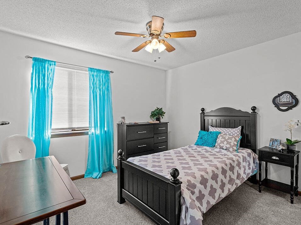 a bedroom with a bed and a ceiling fan
