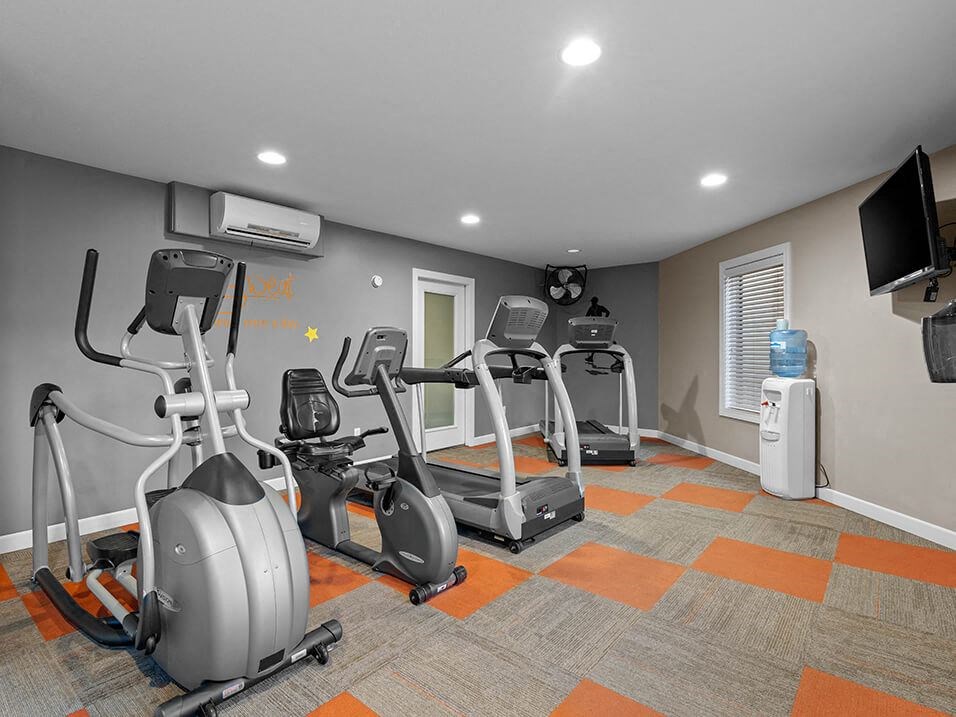 a gym with several exercise bikes and a tv