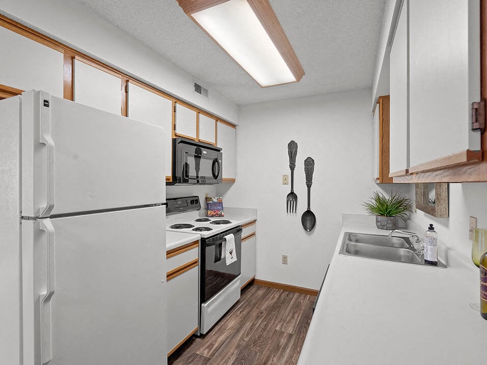 a kitchen with a stove refrigerator and sink