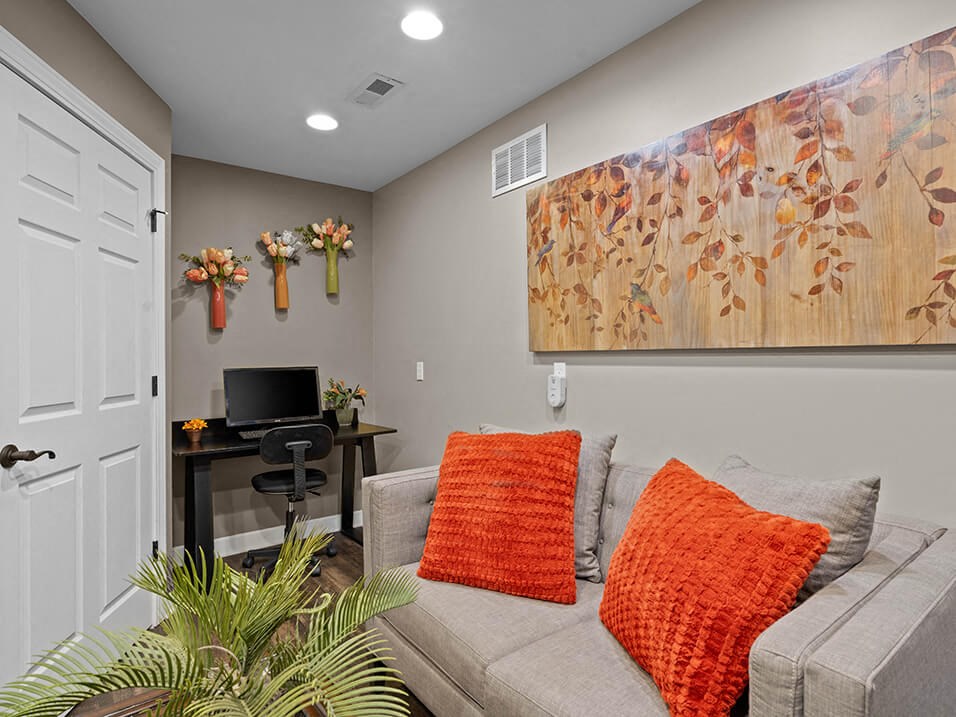 lounge seating area with desk and computer