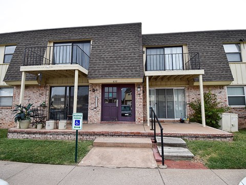 the front of a brick house with a purple door