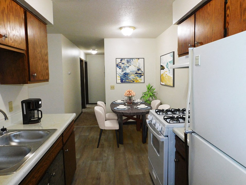 Kitchen area with refrigerator, oven, and double sink at west broadway apartments