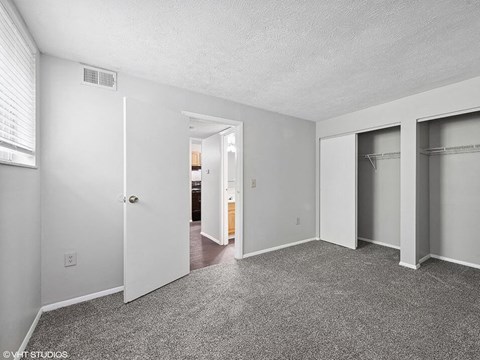 a bedroom with a closet and mirrored closet doors