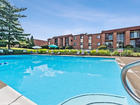 a large swimming pool with an apartment building in the background