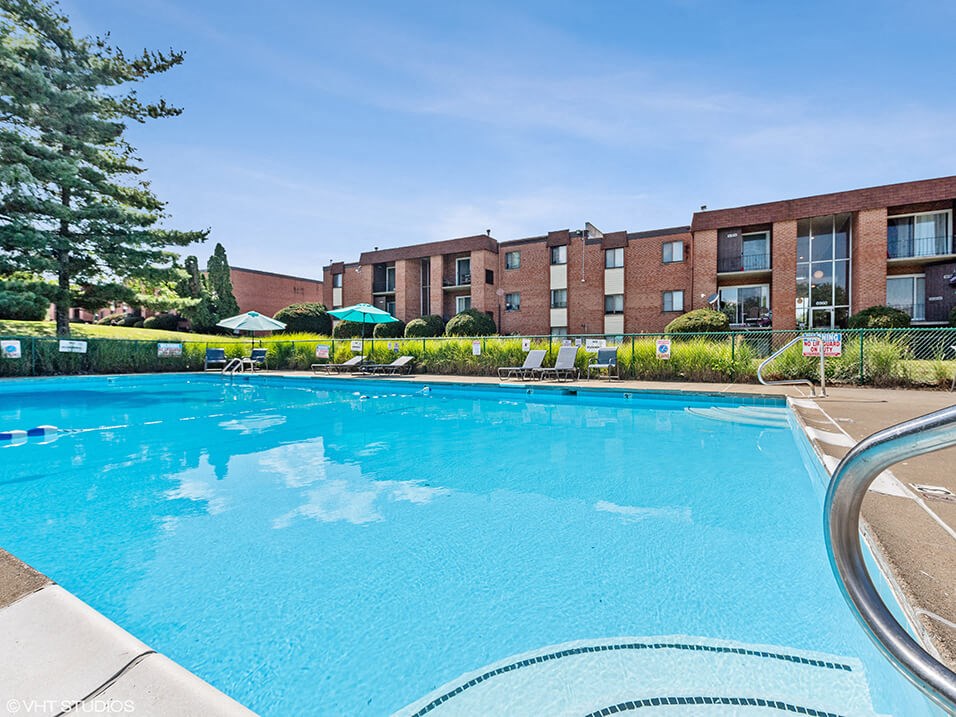 a large swimming pool with an apartment building in the background