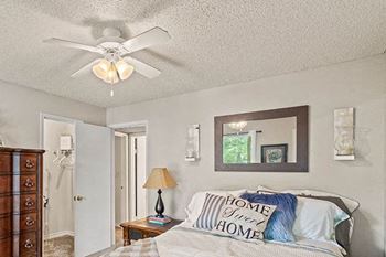 a bedroom with a bed and a ceiling fan