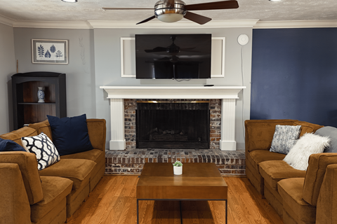 A living room with a fireplace and a television.