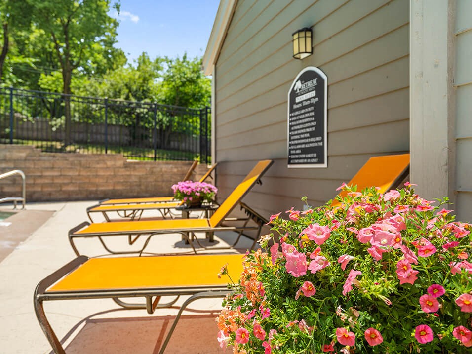 a patio with benches by the pool
