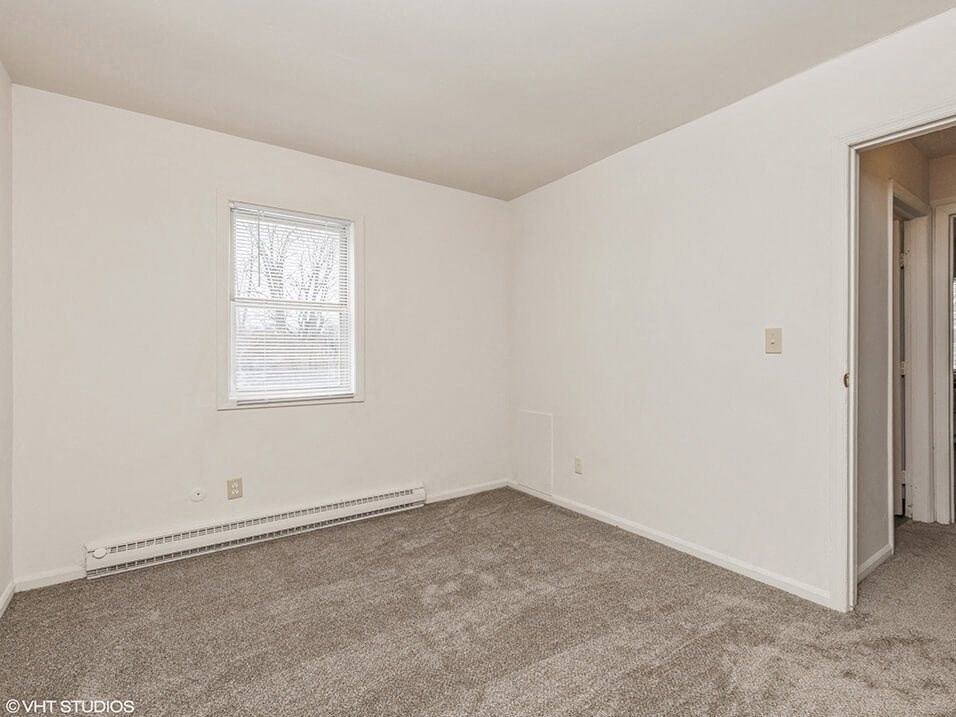 an empty room with carpet and a window