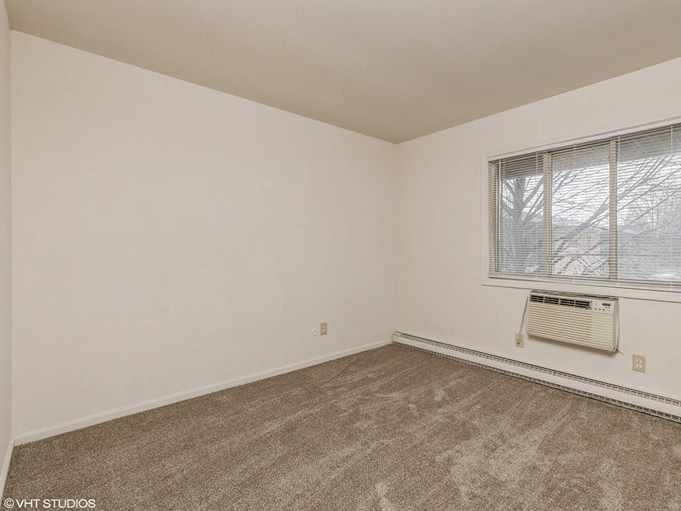 an empty room with a window and a radiator