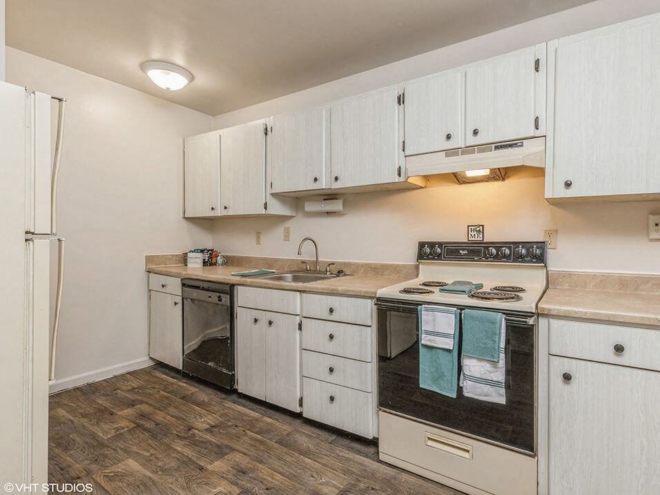 a kitchen with white cabinets and a stove and a sink