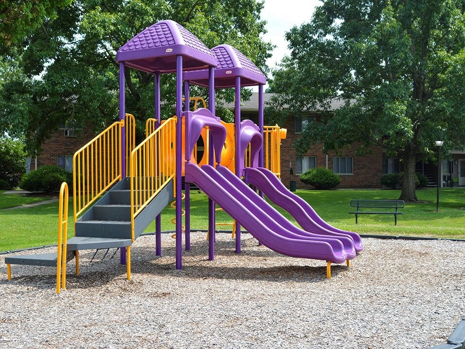 a childrens playground with a purple slide