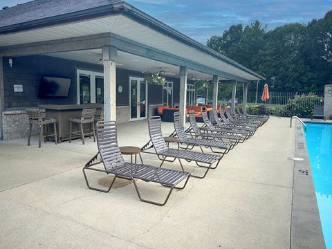 a row of lounge chairs next to a swimming pool