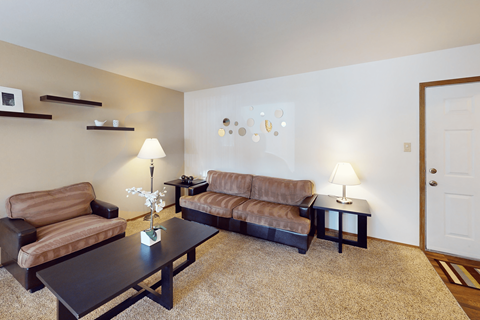 A living room with brown couches and a coffee table.