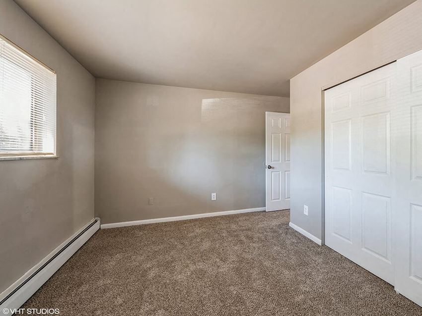 an empty bedroom with a closet and a door