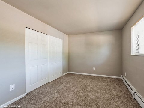 a bedroom with two closets and a carpeted floor