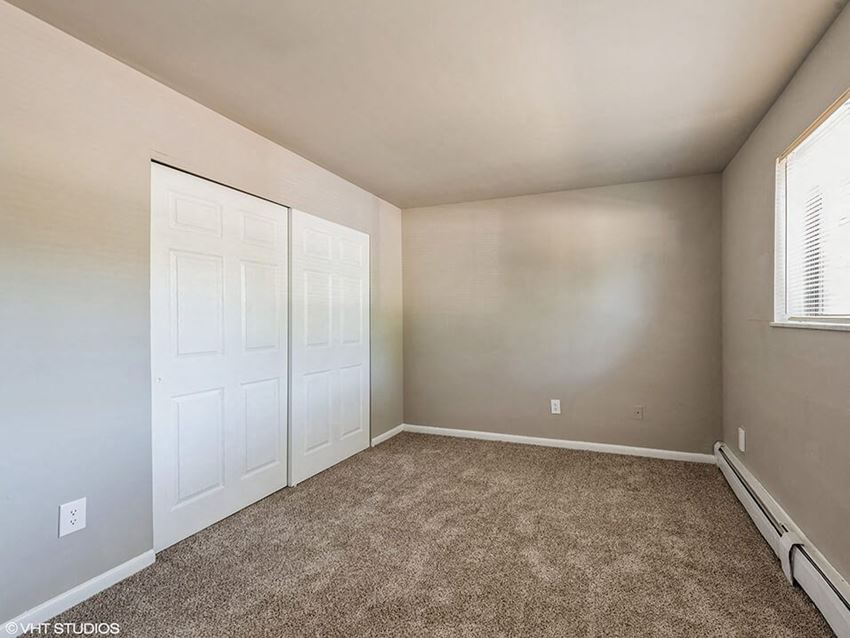 a bedroom with two closets and a carpeted floor