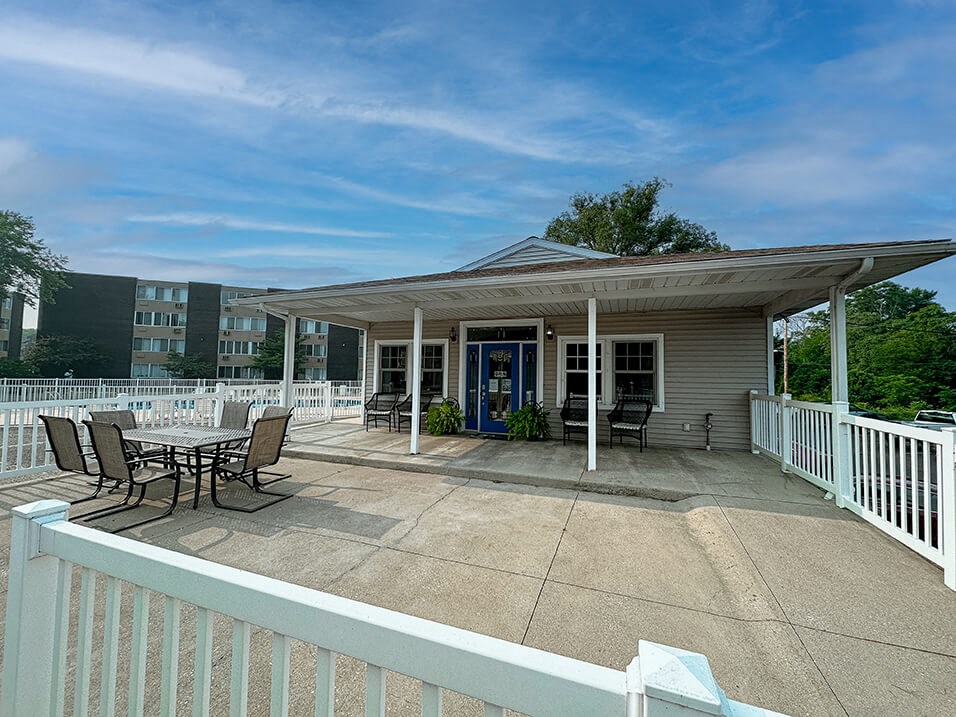 a covered patio with a table and chairs on a porch