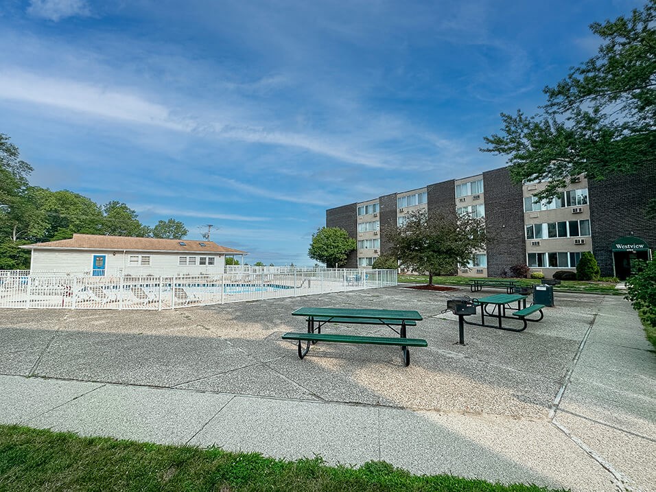 a park with a picnic table in front of an apartment building