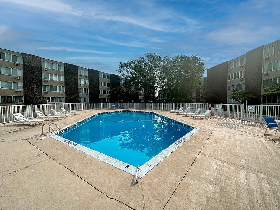 a swimming pool in front of an apartment building