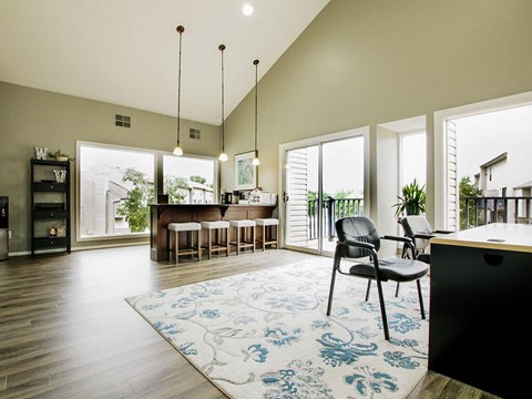 a living room and dining room with a bar and a rug