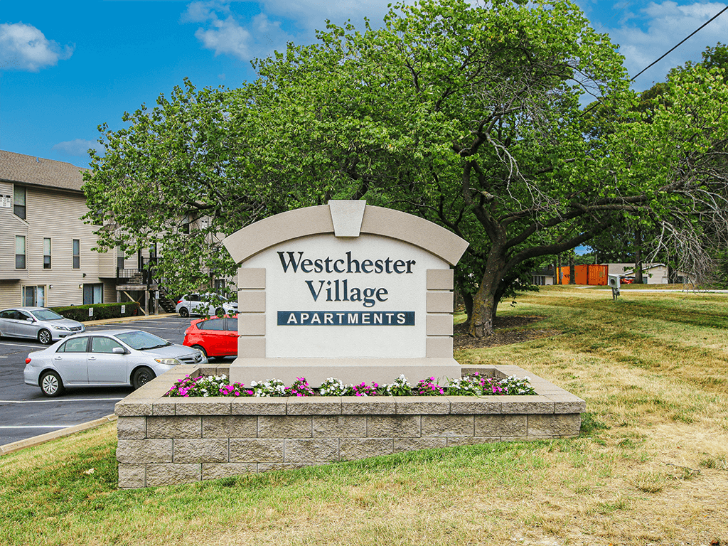the sign apartments in front of a parking lot