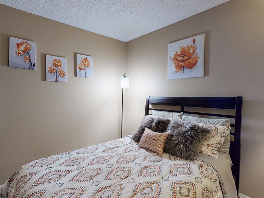 a bedroom with a bed and paintings on the wall