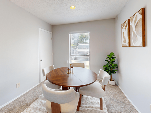A dining room with a round table and chairs.