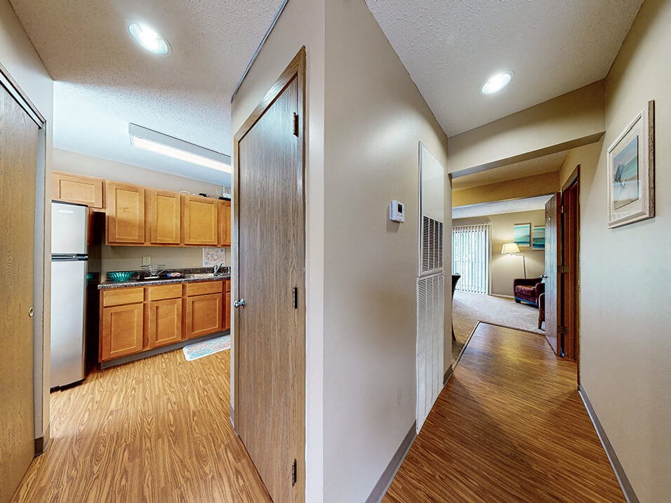 a view of the kitchen and living room from the hallway