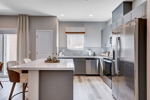 A modern kitchen with a dining table and chairs.