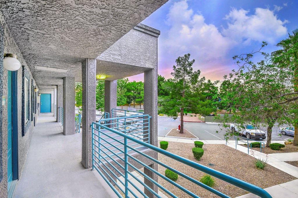 a balcony with blue railings and a parking lot