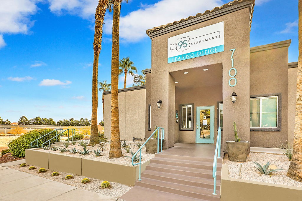 the front of a building with palm trees