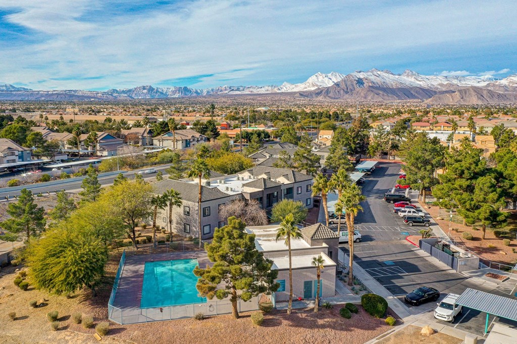 an aerial view of a community with a pool and mountains in the background