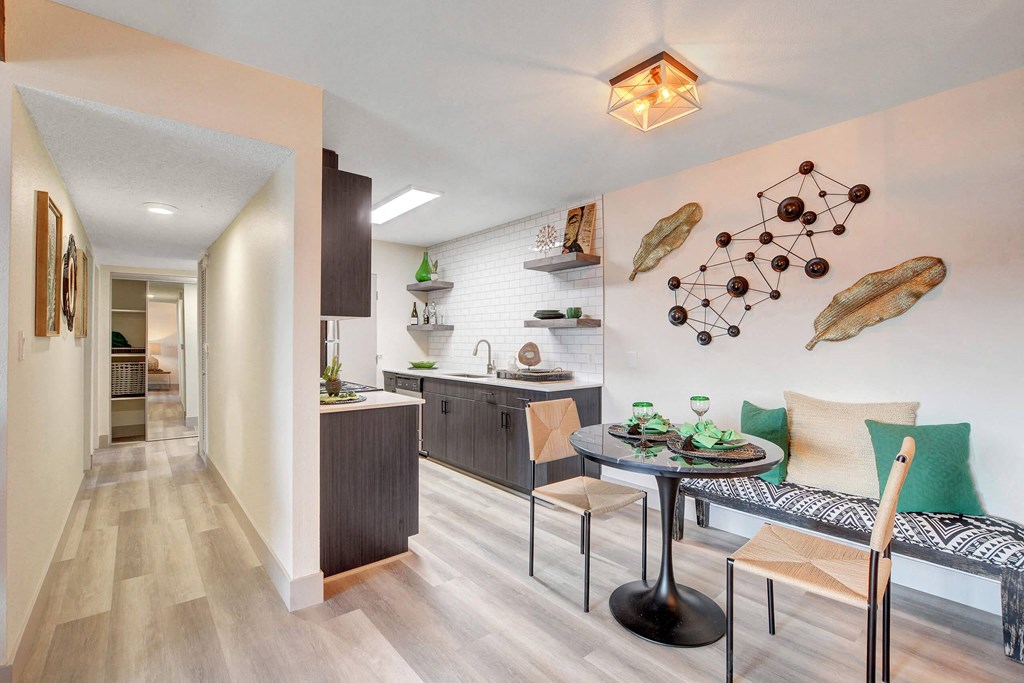 A modern kitchen with a dining table and chairs. at Namaste Apartments, Las Vegas, Nevada