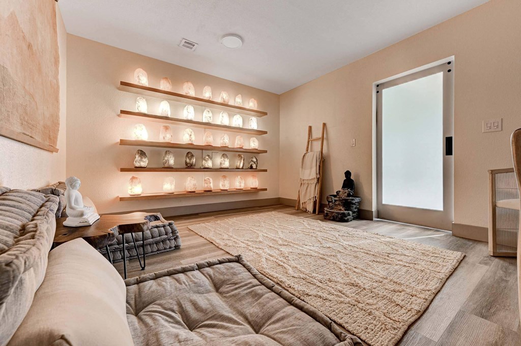A living room with a couch, a rug, and a wall with lights on it. at Namaste Apartments, Las Vegas, NV, 89102