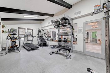 A gym with a variety of equipment including treadmills, weights, and exercise machines. at Namaste Apartments, Nevada