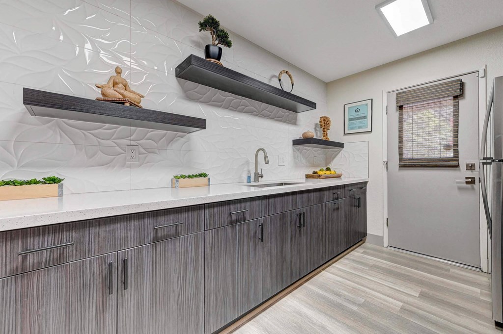 A kitchen with a white counter top and grey cabinets. at Namaste Apartments, Nevada