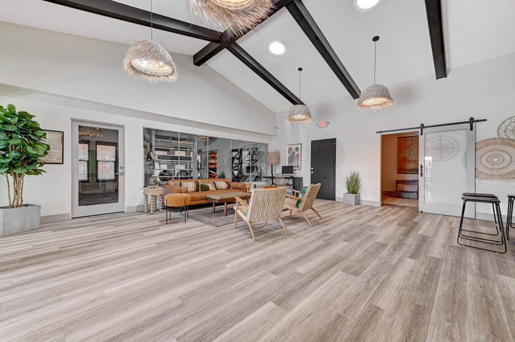 A living room with a wooden floor and a large window. at Namaste Apartments, Las Vegas, Nevada