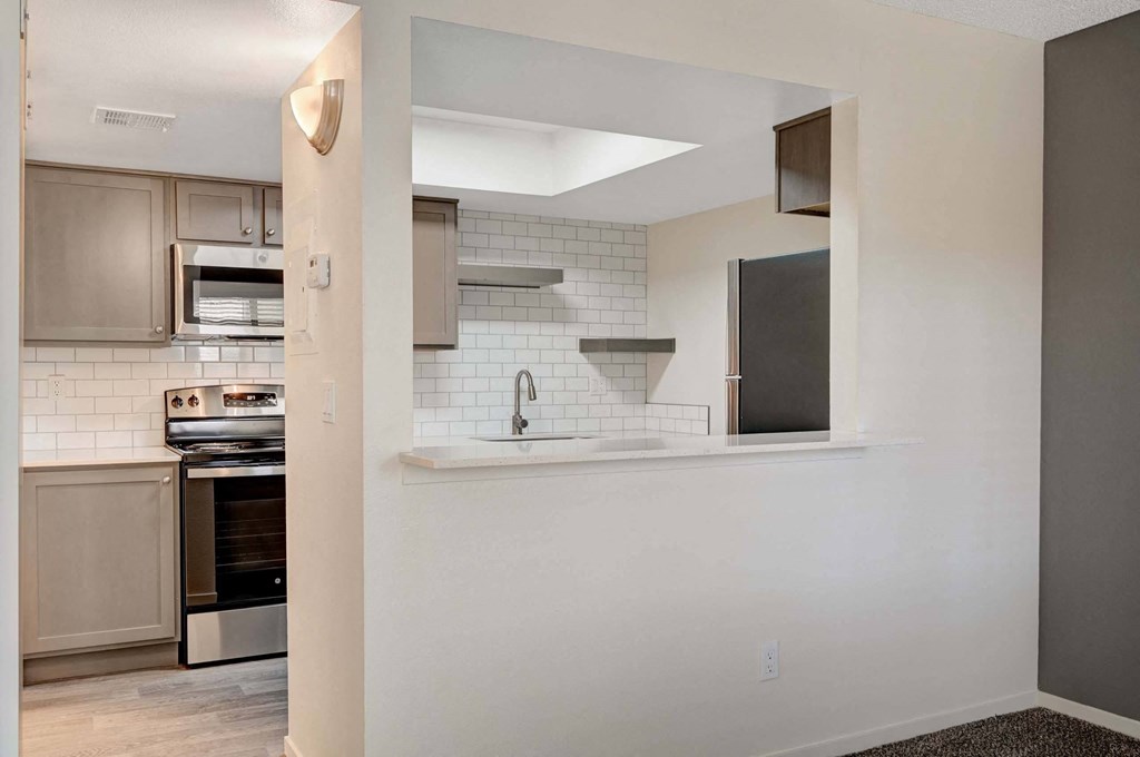 A kitchen with a stove top oven and a microwave. at Solstice Apartment Homes, Las Vegas, NV, 89108
