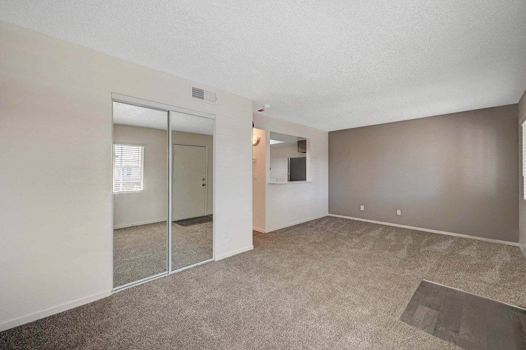 A room with a carpeted floor and a sliding glass door. at Solstice Apartment Homes, Las Vegas, Nevada