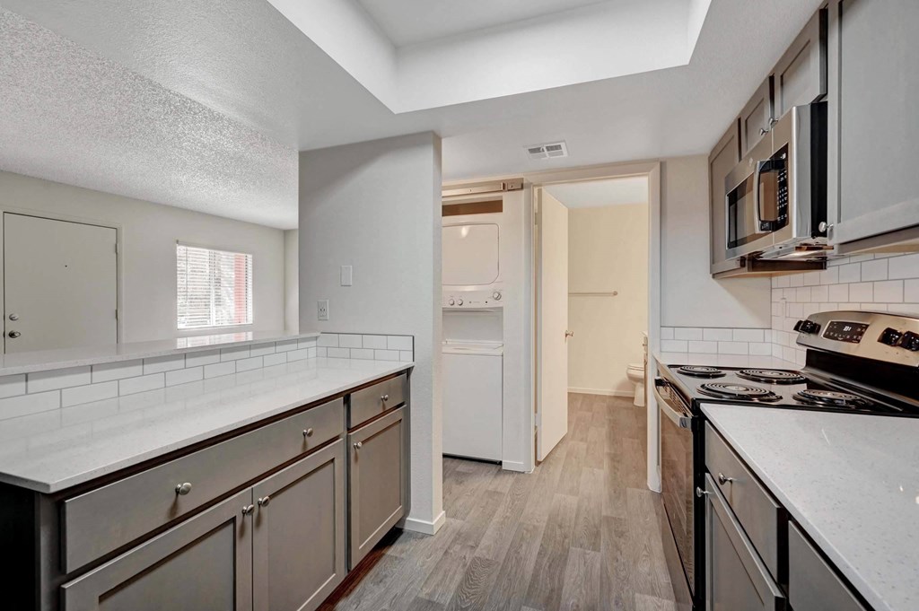 A kitchen with white countertops and stainless steel appliances. at Solstice Apartment Homes, Las Vegas, 89108