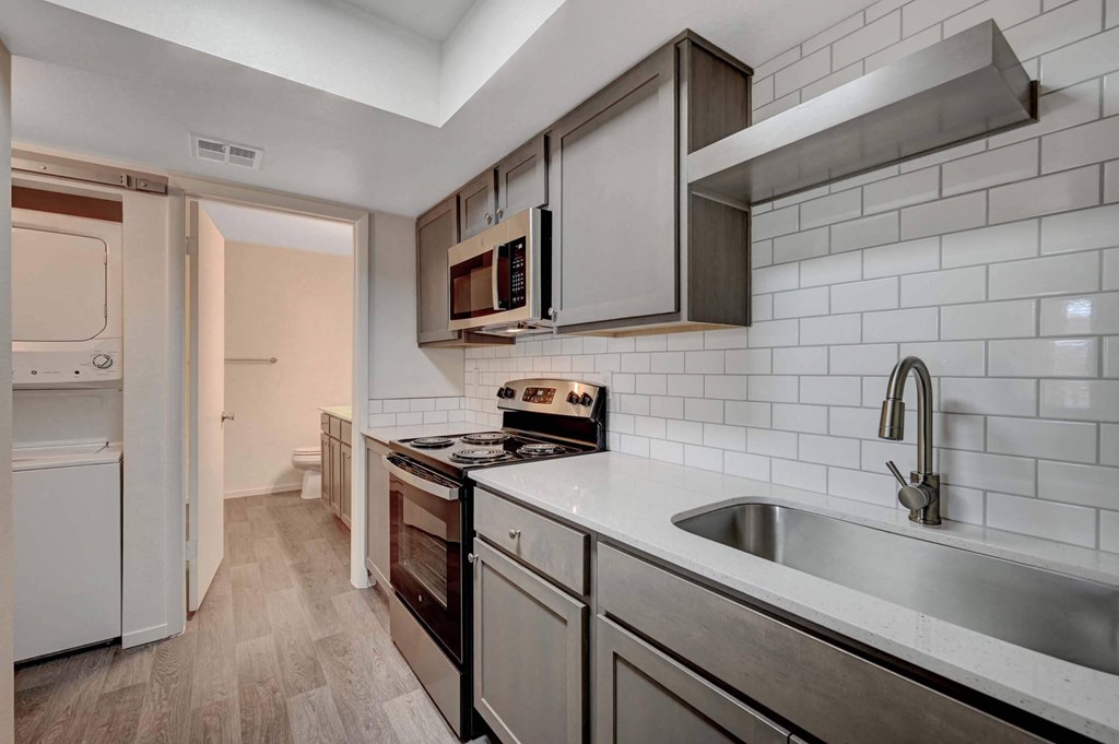 A kitchen with a white fridge and a stove top oven. at Solstice Apartment Homes, Nevada