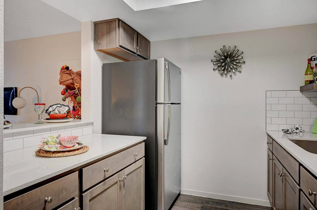 A kitchen with a refrigerator, countertop, and cabinets. at Solstice Apartment Homes, Nevada, 89108