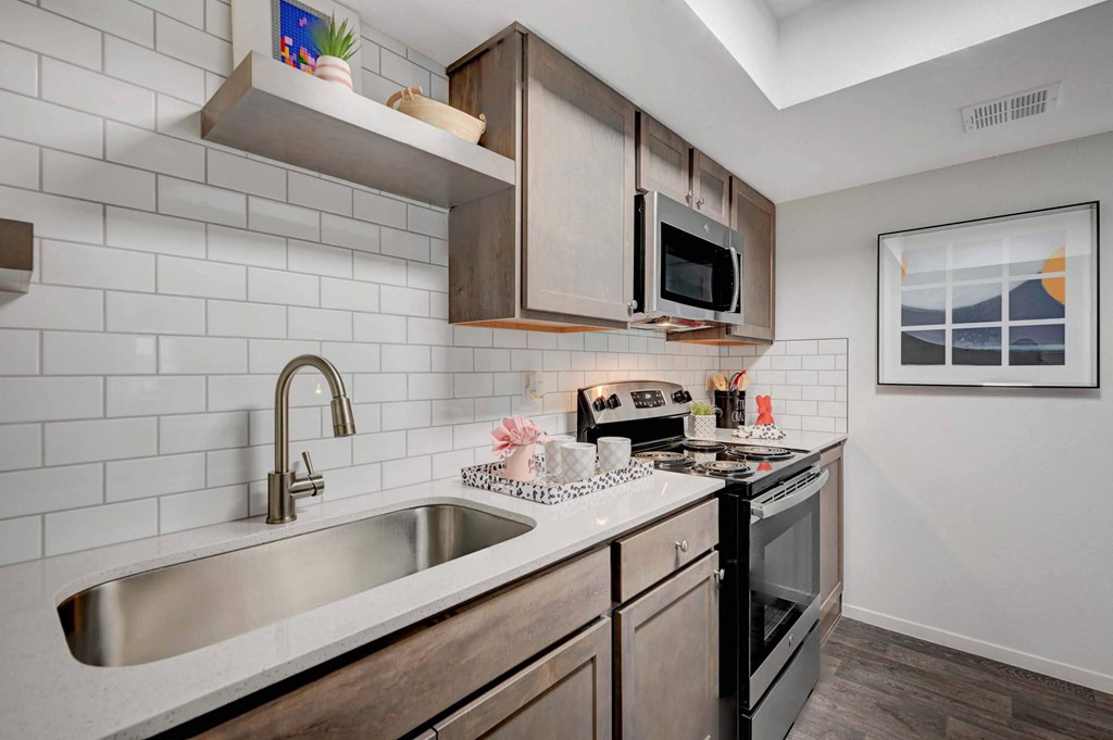 A kitchen with a white sink and black oven. at Solstice Apartment Homes, Las Vegas, 89108
