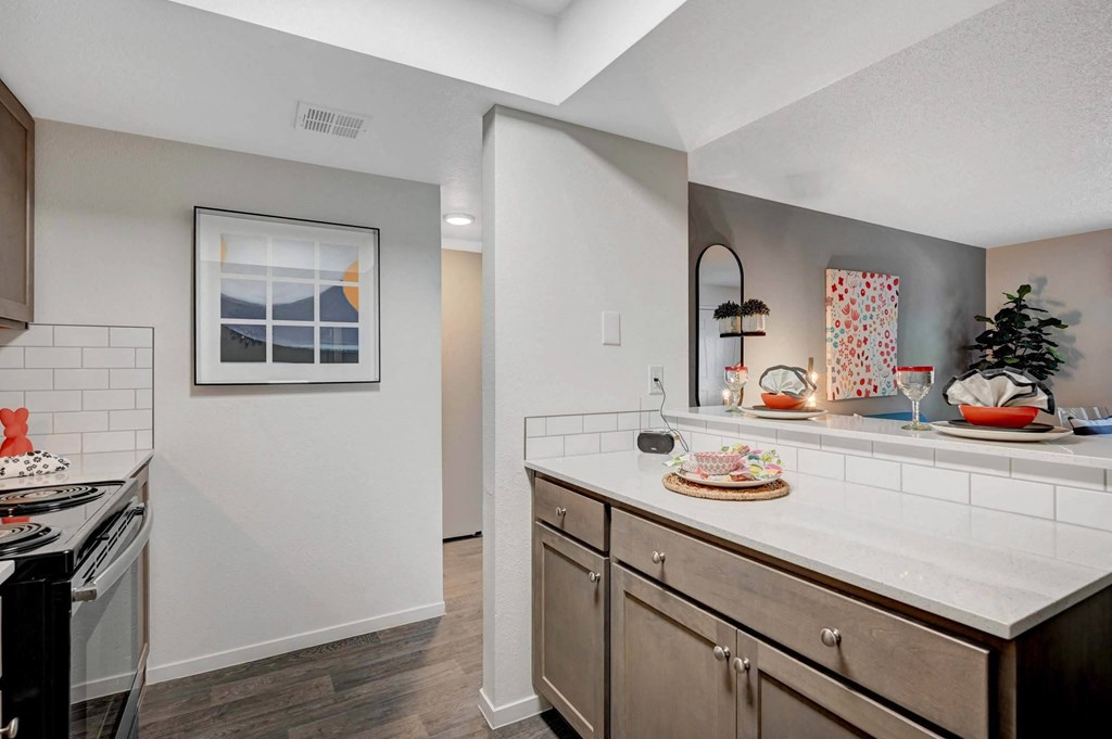 A kitchen with a white counter top and wooden cabinets. at Solstice Apartment Homes, Las Vegas, 89108