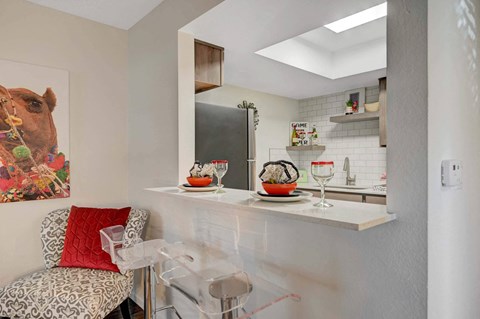 A kitchen with a white counter and a painting of a camel on the wall.